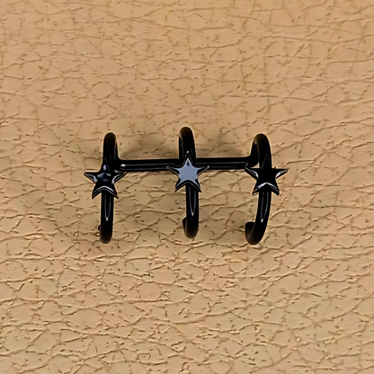 Black star-shaped wall hooks on a beige textured wall