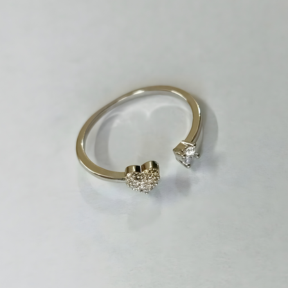 Silver open ring with heart-shaped and round diamond-like embellishments on a light gray background