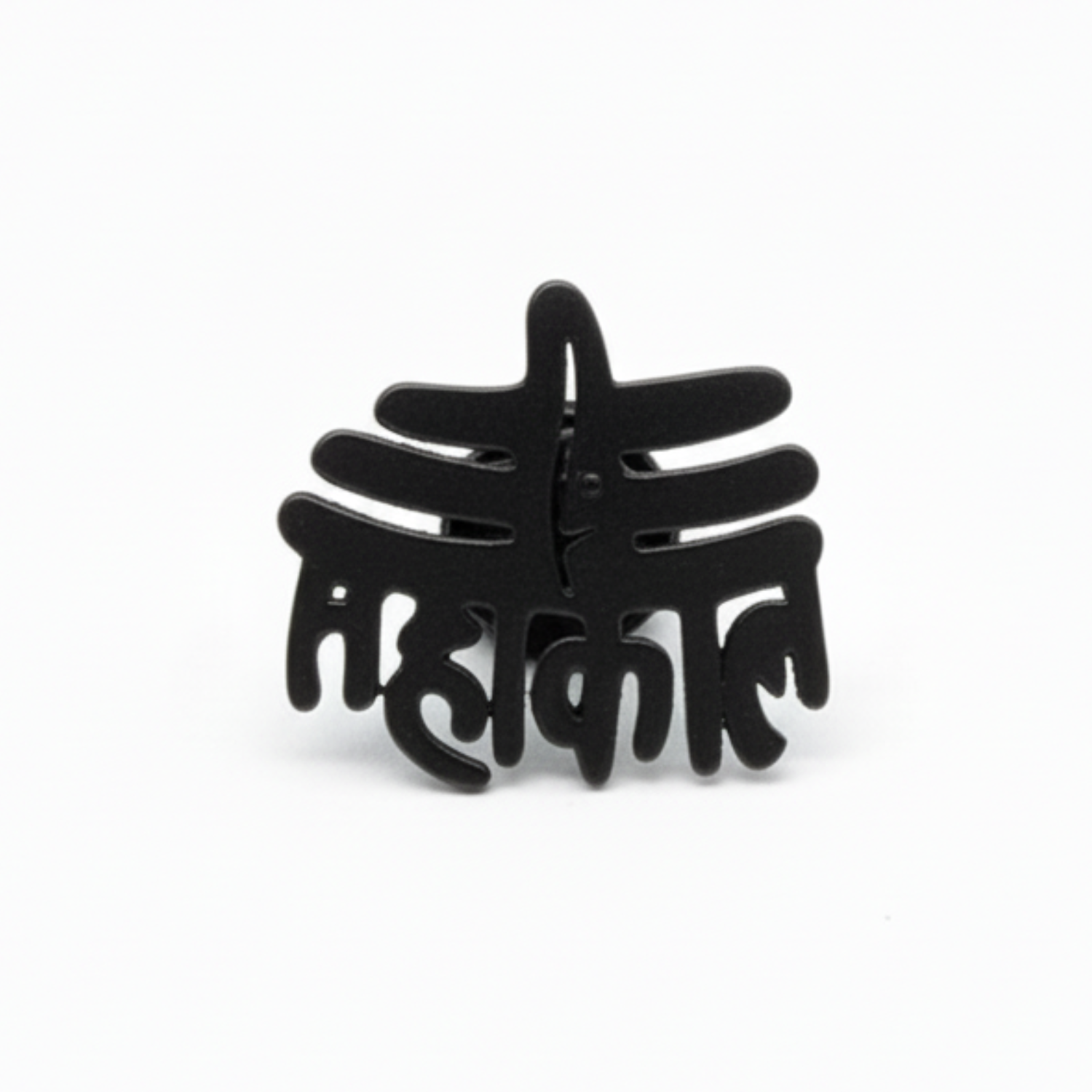 Black decorative item with intricate design on a white background