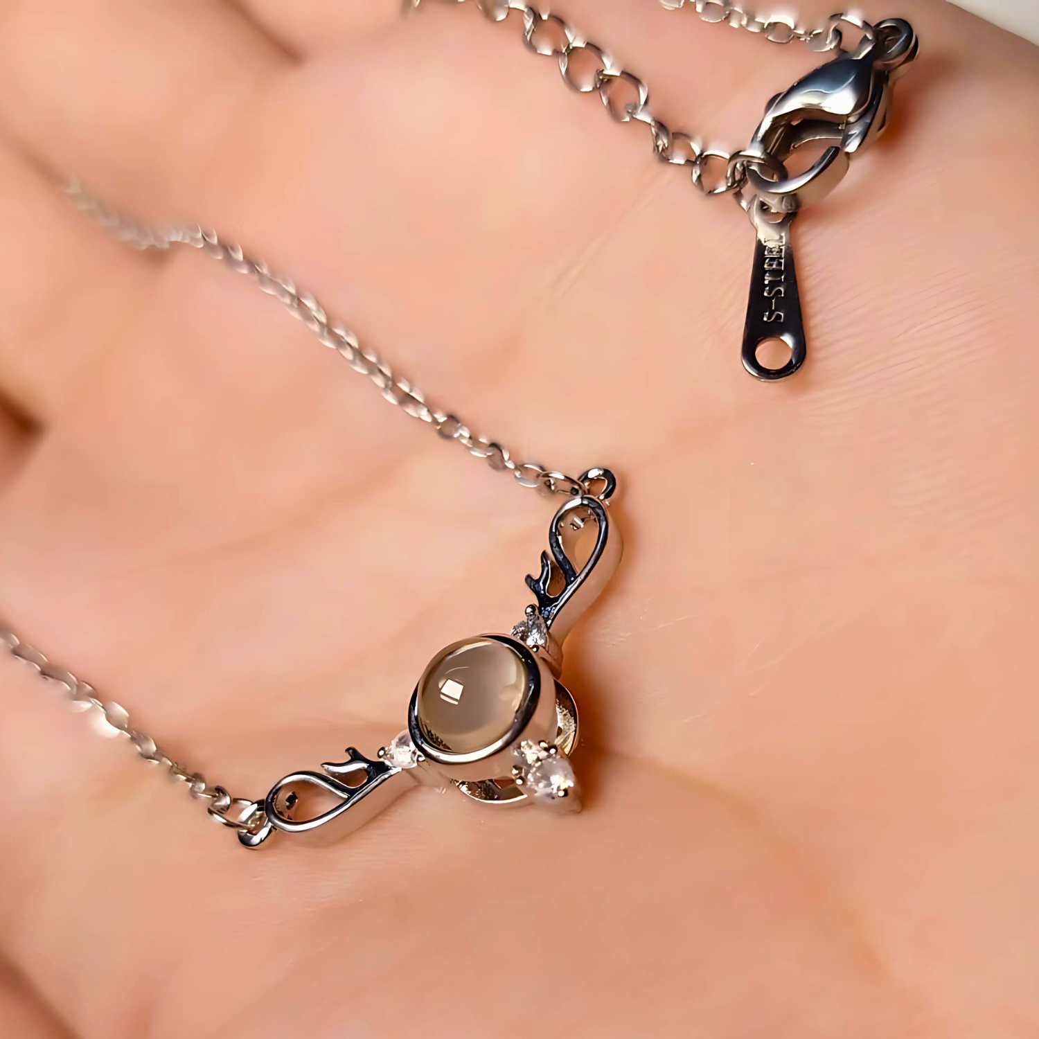 Silver necklace with a pendant on a hand