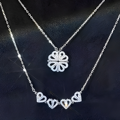 Silver necklace with heart-shaped pendant on a dark fabric background