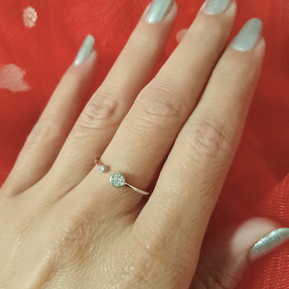 Close-up of a hand wearing a diamond ring against a red background