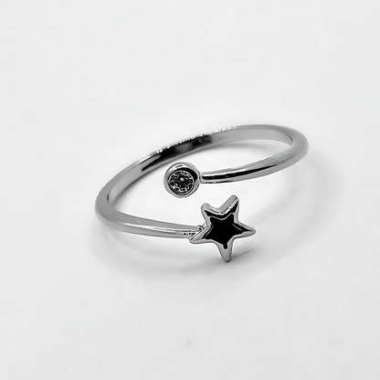 Silver ring with a star-shaped gem on a light gray background