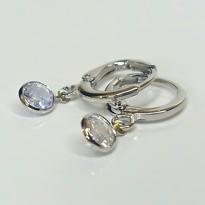 Pair of silver earrings with round gemstones on a white background