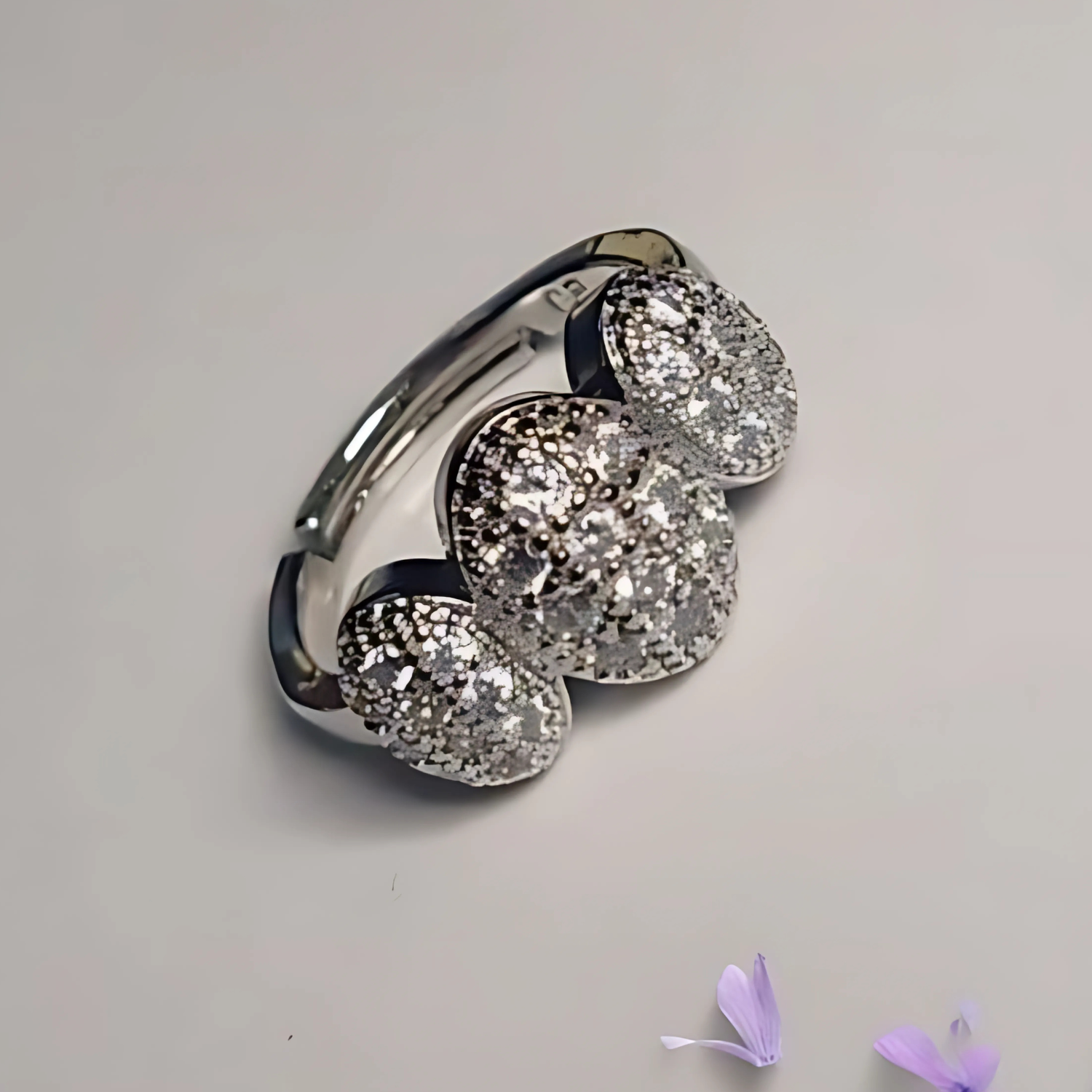 Silver ring with three large gemstones on a light gray background