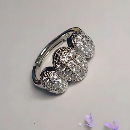 Silver ring with three large gemstones on a light gray background