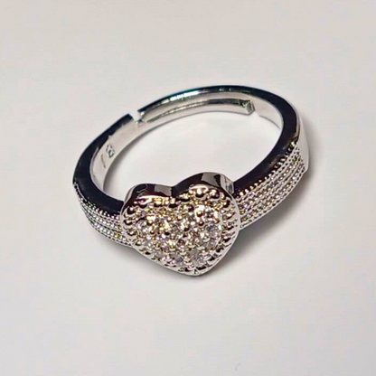 Silver hoop earring with a heart-shaped gemstone on a light gray background