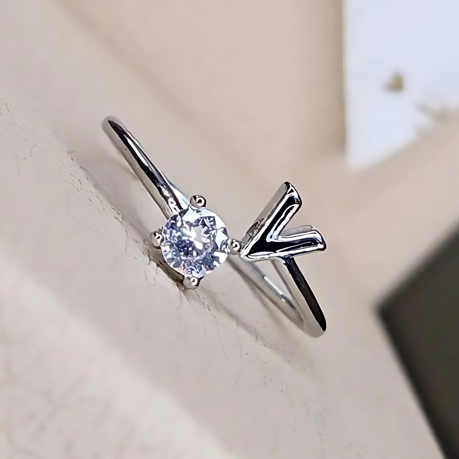 Silver ring with a diamond on a light background