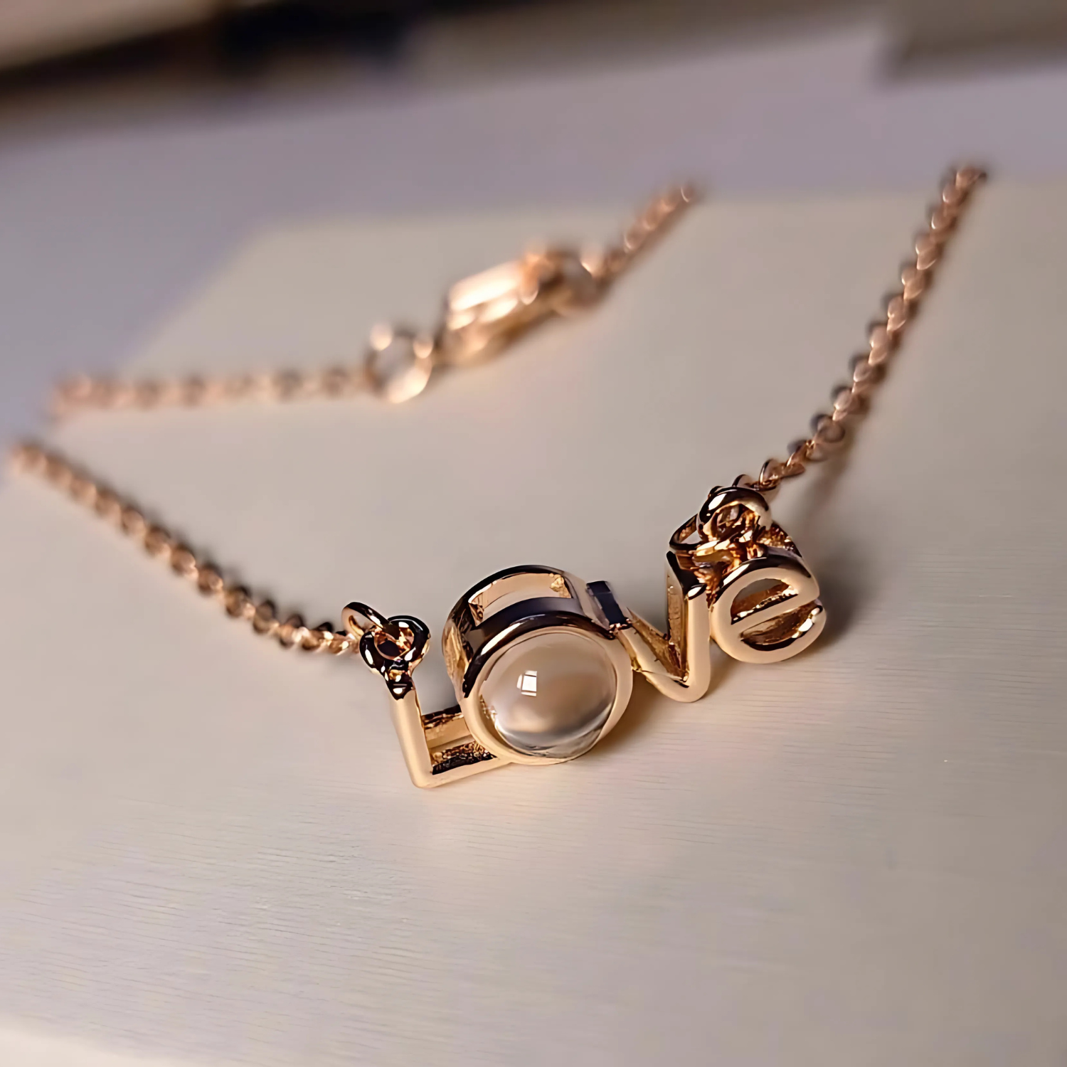 Rose gold necklace with a unique pendant on a light background