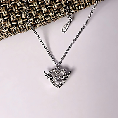 Silver necklace with a heart-shaped pendant on a light background