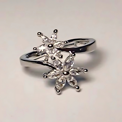 Silver ring with star-shaped gemstones on a light gray background