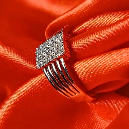 Silver comb-shaped hair clip with clear stones on a red satin background