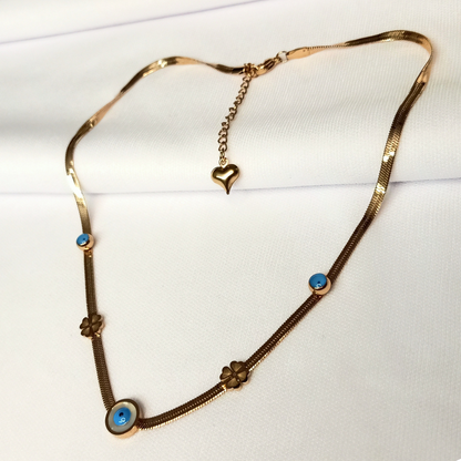Gold necklace with blue stones and heart pendant on a white background