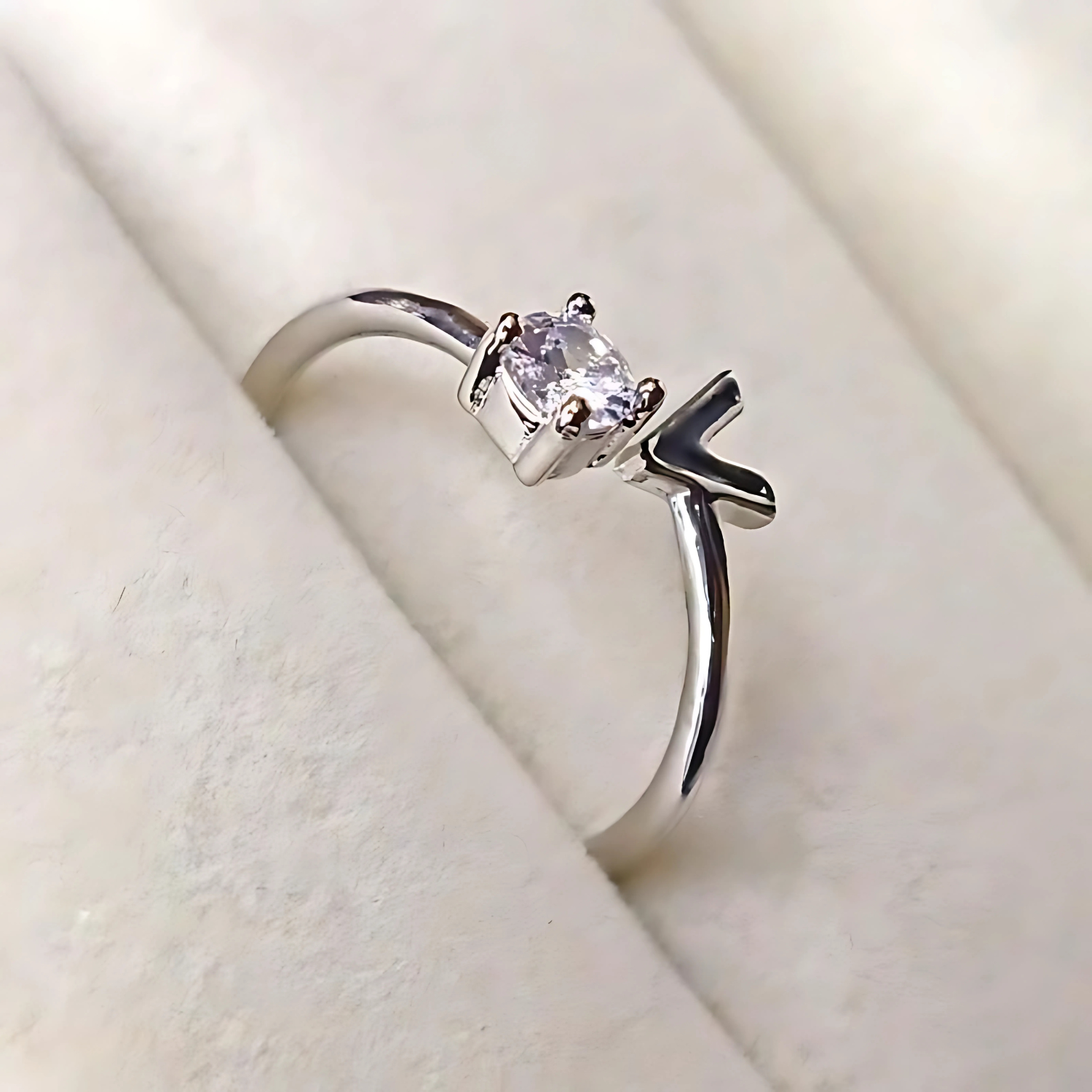 Silver ring with a gemstone on a soft beige background