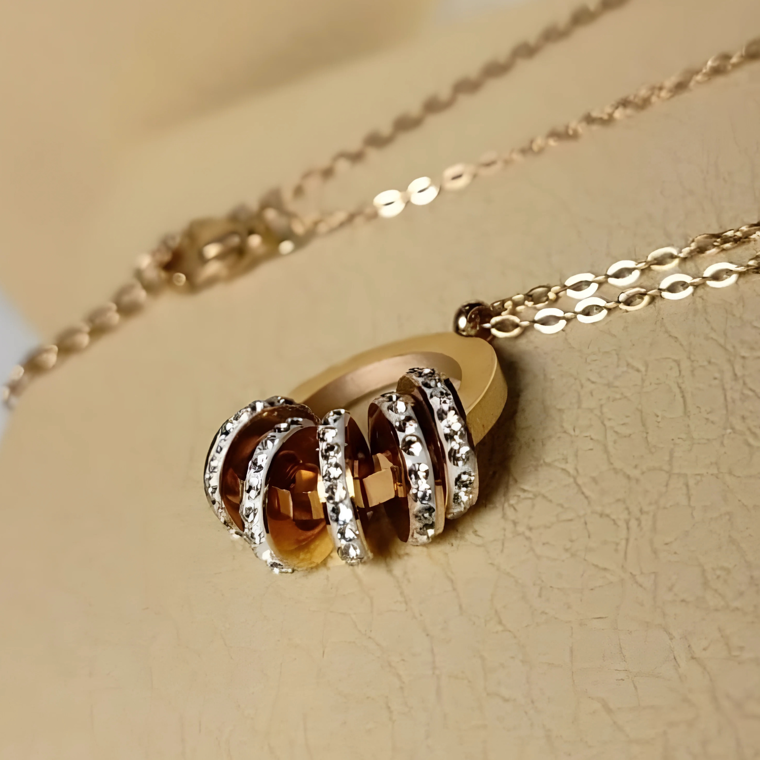 Gold necklace with a pendant on a beige background